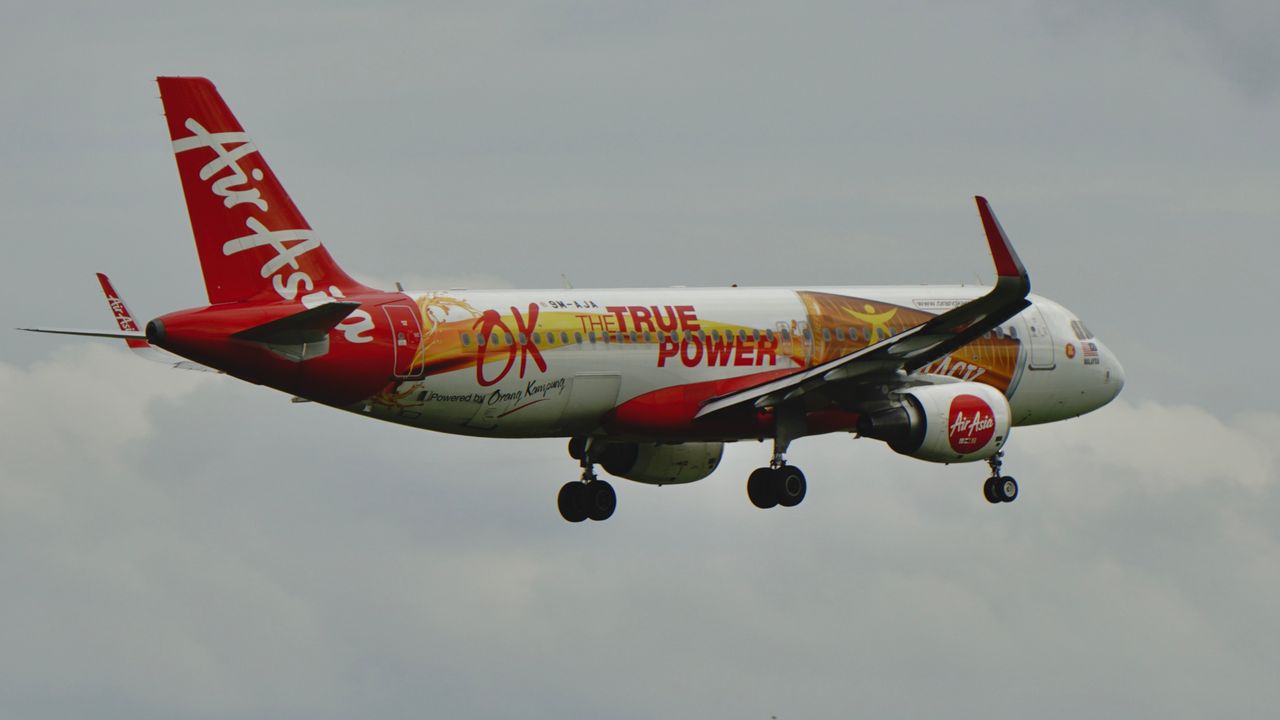 creative-03 Dynamic AirAsia aircraft flying with unique 'OX The True Power' design.